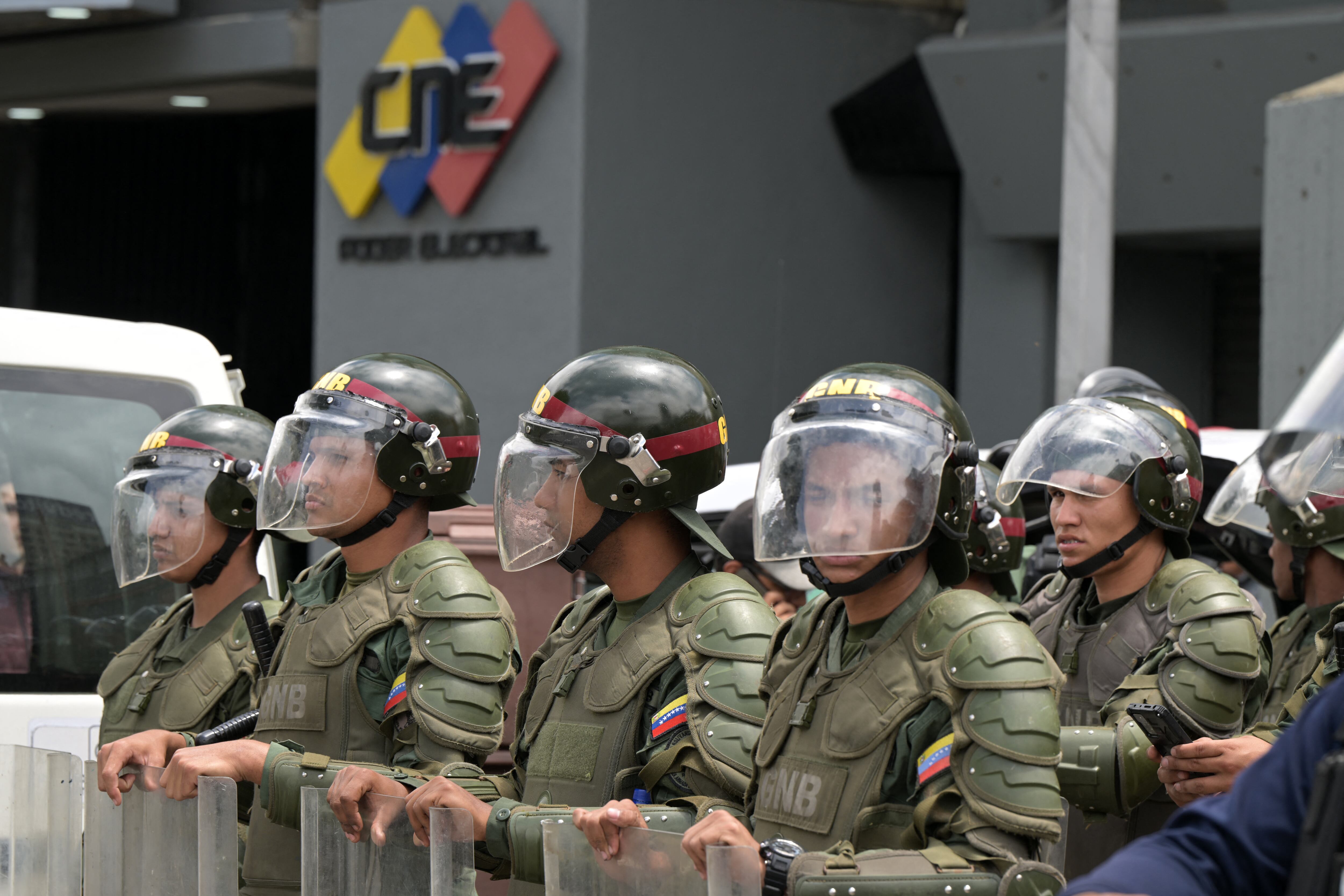 Miembros de la Guardia Nacional hacen guardia frente a una de las sedes del Consejo Nacional Electoral (CNE) en Caracas el 29 de julio de 2024, un día después de las elecciones presidenciales venezolanas. El presidente Nicolás Maduro fue declarado ganador de las elecciones presidenciales de Venezuela, pero la oposición y los principales vecinos regionales rechazaron de inmediato los resultados oficiales. (Foto de Yuri CORTEZ / AFP)