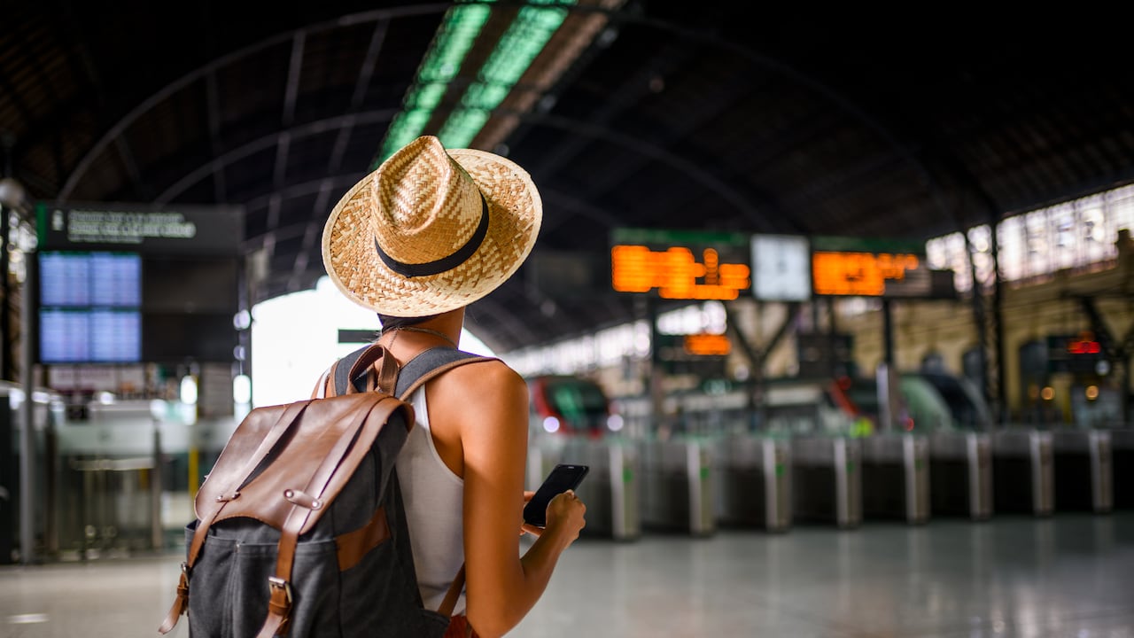 Mujer viajera en la estación de tren esperando su tren.