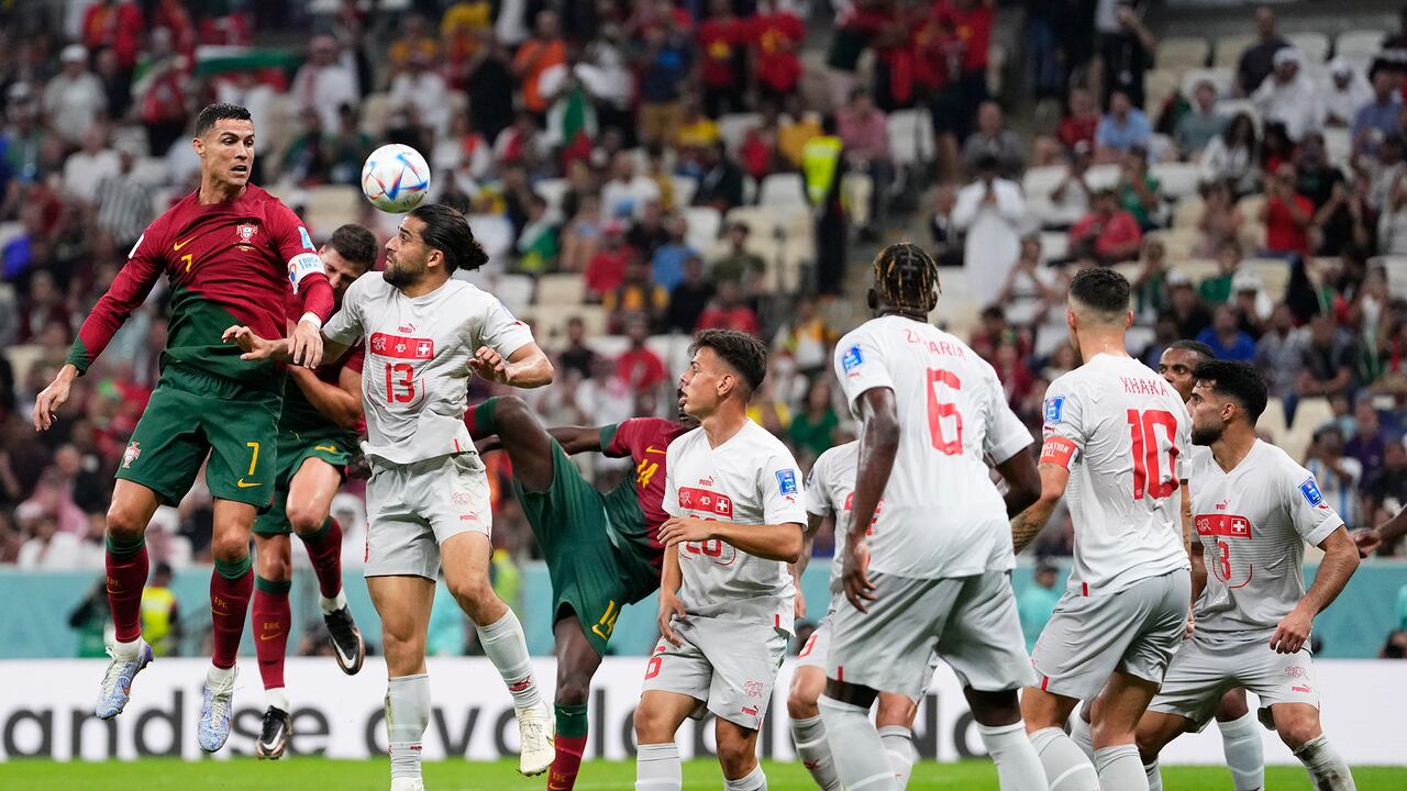 El portugués Cristiano Ronaldo, a la izquierda, y el suizo Ricardo Rodríguez lanzan un cabezazo durante el partido de fútbol de los octavos de final de la Copa Mundial entre Portugal y Suiza, en el Estadio Lusail en Lusail, Qatar, el martes 6 de diciembre de 2022.
