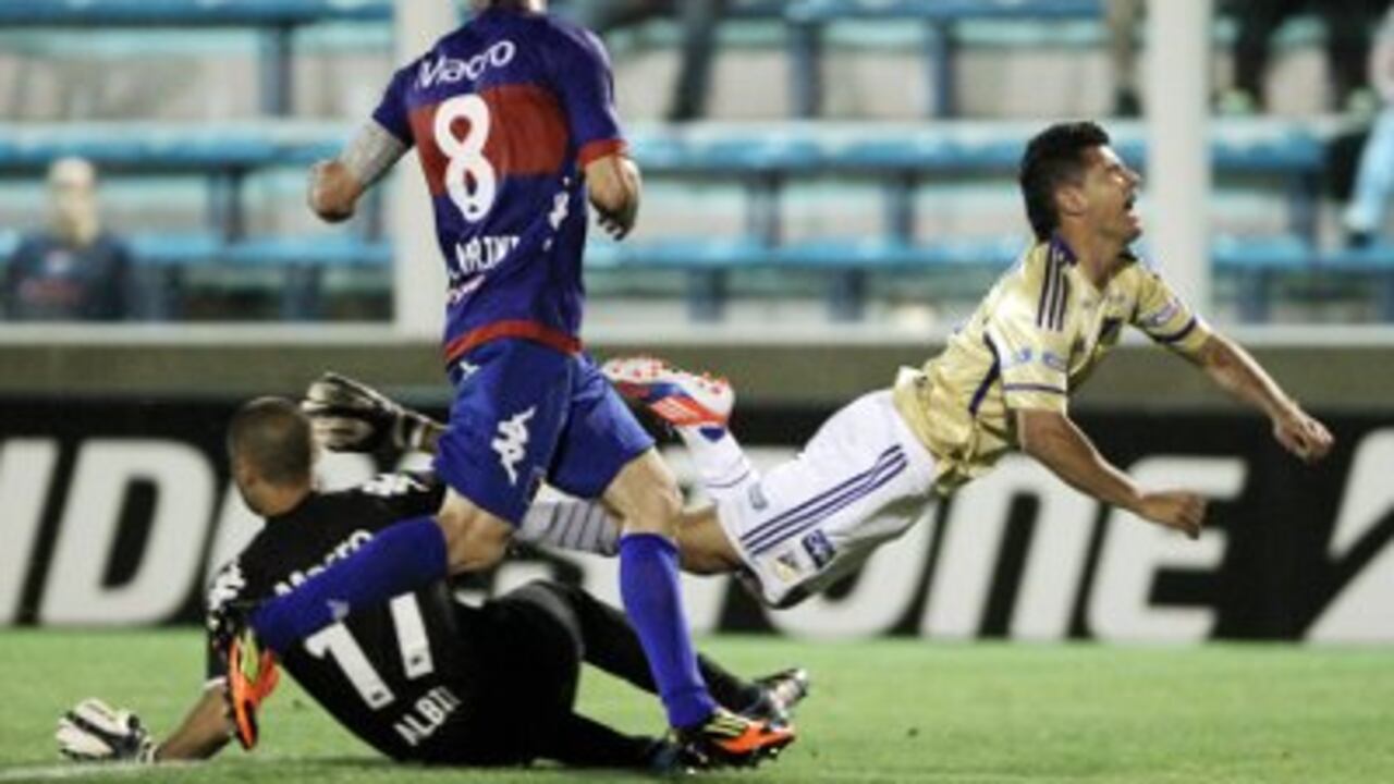 Harison Otálvaro (d) cuando jugaba en Millonarios, cae al piso.
