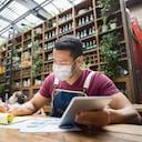 Retrato de un gerente de negocios haciendo los libros en un restaurante con una máscara facial durante la pandemia de COVID-19 - reapertura del negocio