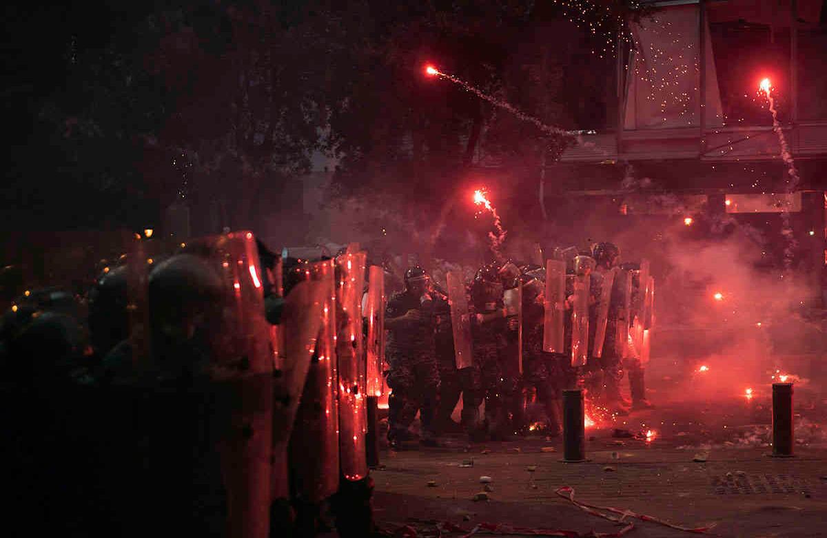 Los fuegos artificiales lanzados por manifestantes antigubernamentales caen sobre la policía antidisturbios durante los enfrentamientos cerca del edificio del parlamento. AP Photo/Felipe Dana.