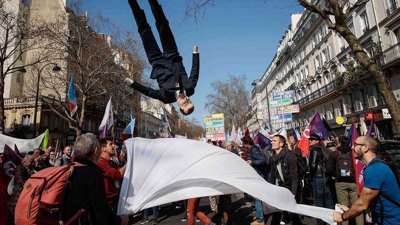 Un títere del presidente francés Emmanuel Macron sale al aire durante una marcha en Francia