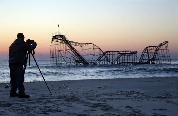 Un hombre en Nueva Jersey (EE.UU.) fotografía una montaña rusa que quedó en el mar luego de la supertormenta Sandy. (AP)