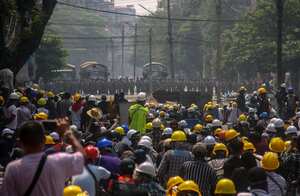 Manifestantes antigolpistas, detrás de barricadas improvisadas, se enfrentan con las fuerzas de seguridad de Myanmar en Yangon, Myanmar, el martes 2 de marzo de 2021. La policía de Myanmar utilizó repetidamente gases lacrimógenos y balas de goma el martes contra las multitudes que protestaban por el golpe del mes pasado, pero los manifestantes se reagruparon después de cada volea y trataron de defenderse con barricadas a medida que se intensificaban los enfrentamientos entre los manifestantes y las fuerzas de seguridad. Foto: AP.