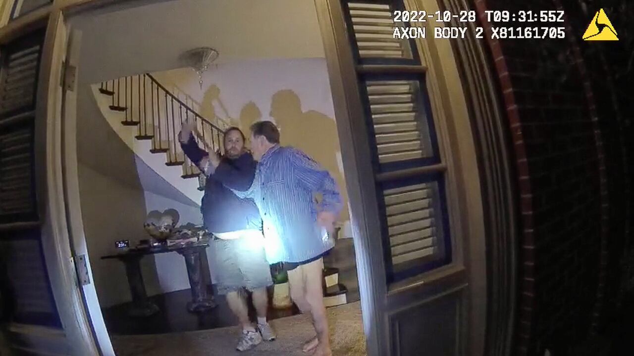 Esta imagen de un video de la cámara corporal de la policía, publicado por el Departamento de Policía de San Francisco, muestra a Paul Pelosi, a la derecha, luchando por el control de un martillo con su agresor, David DePape, durante un ataque en la casa de Pelosi en San Francisco el octubre. 28 de enero de 2022. (San Francisco Police Department via AP)