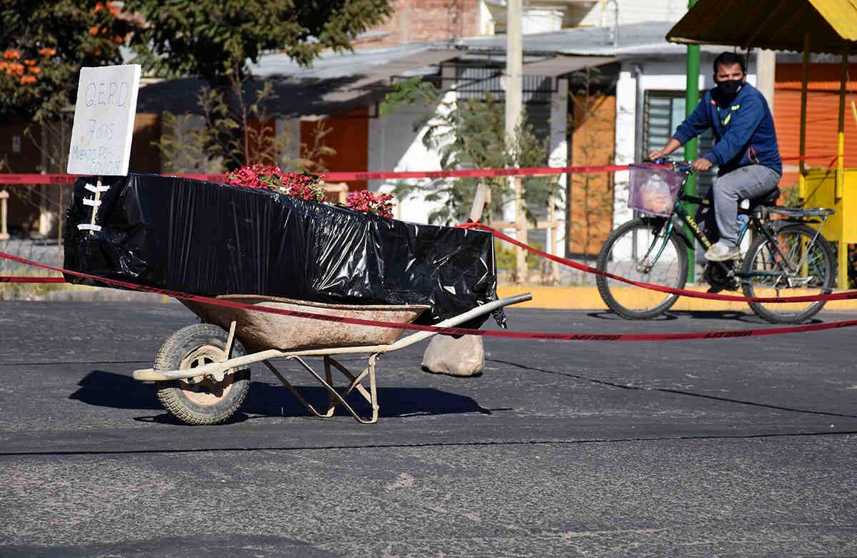 A coffin wrapped in plastic containing the remains of an unidentified men, who died last week, sits on a wheelbarrow in the middle of a street, placed there by his family to draw attention of the authorities to show that his remains are yet to be collected, in Cochabamba, Bolivia, Saturday, July 4, 2020. Funeral services in Cochabamba are overwhelmed and bodies are piling up, waiting for cremation or burial, as new coronavirus cases rapidly multiply in one of the epicenters of the pandemic in Bolivia. (AP Photo/Dico Soliz)