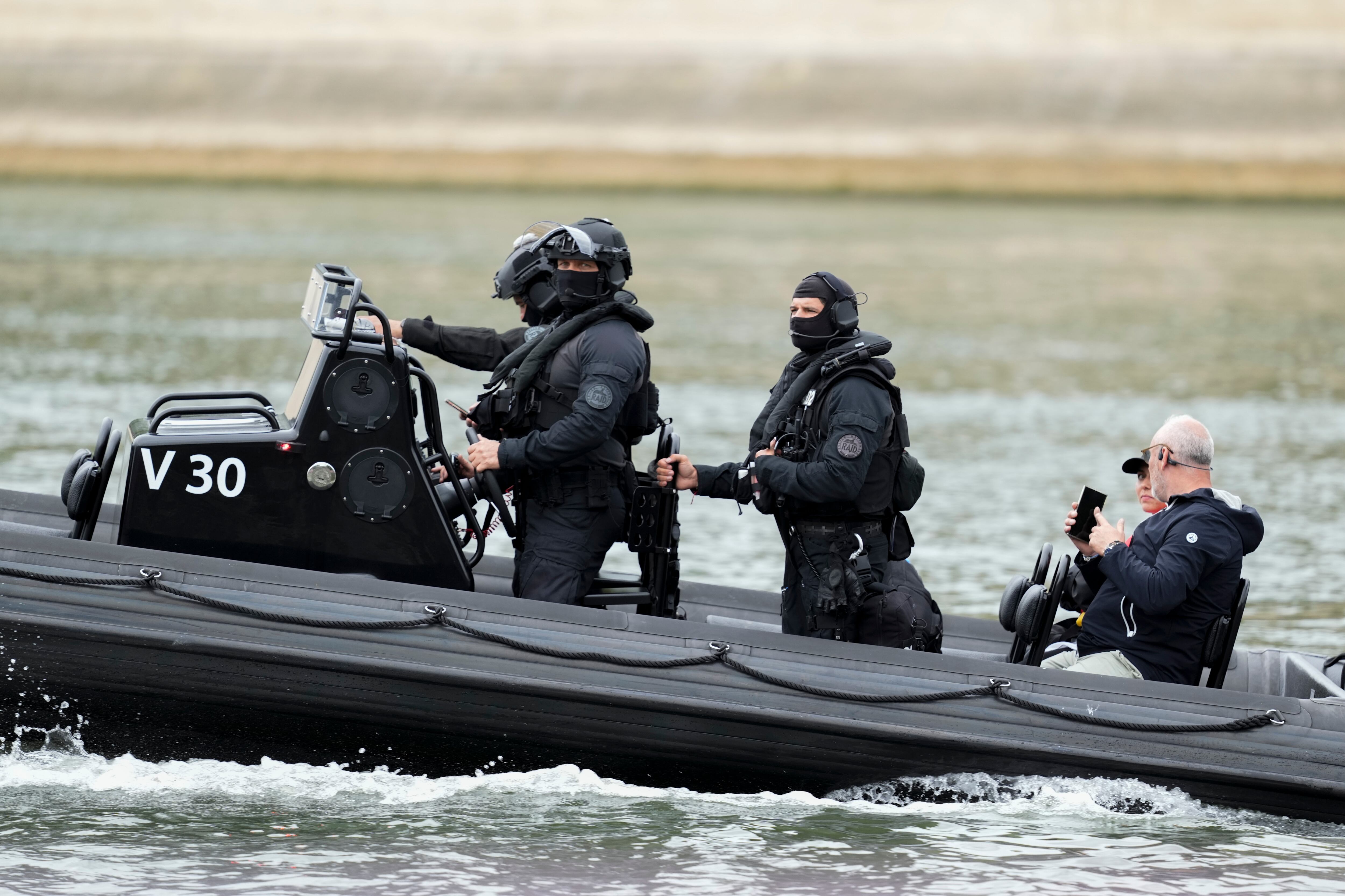 Miembros de las fuerzas de seguridad en un bote patrulla patrullando a lo largo del río Sena en París, Francia, antes de la ceremonia de apertura de los Juegos Olímpicos de Verano de 2024, el viernes 26 de julio de 2024. (Foto AP/Luca Bruno)