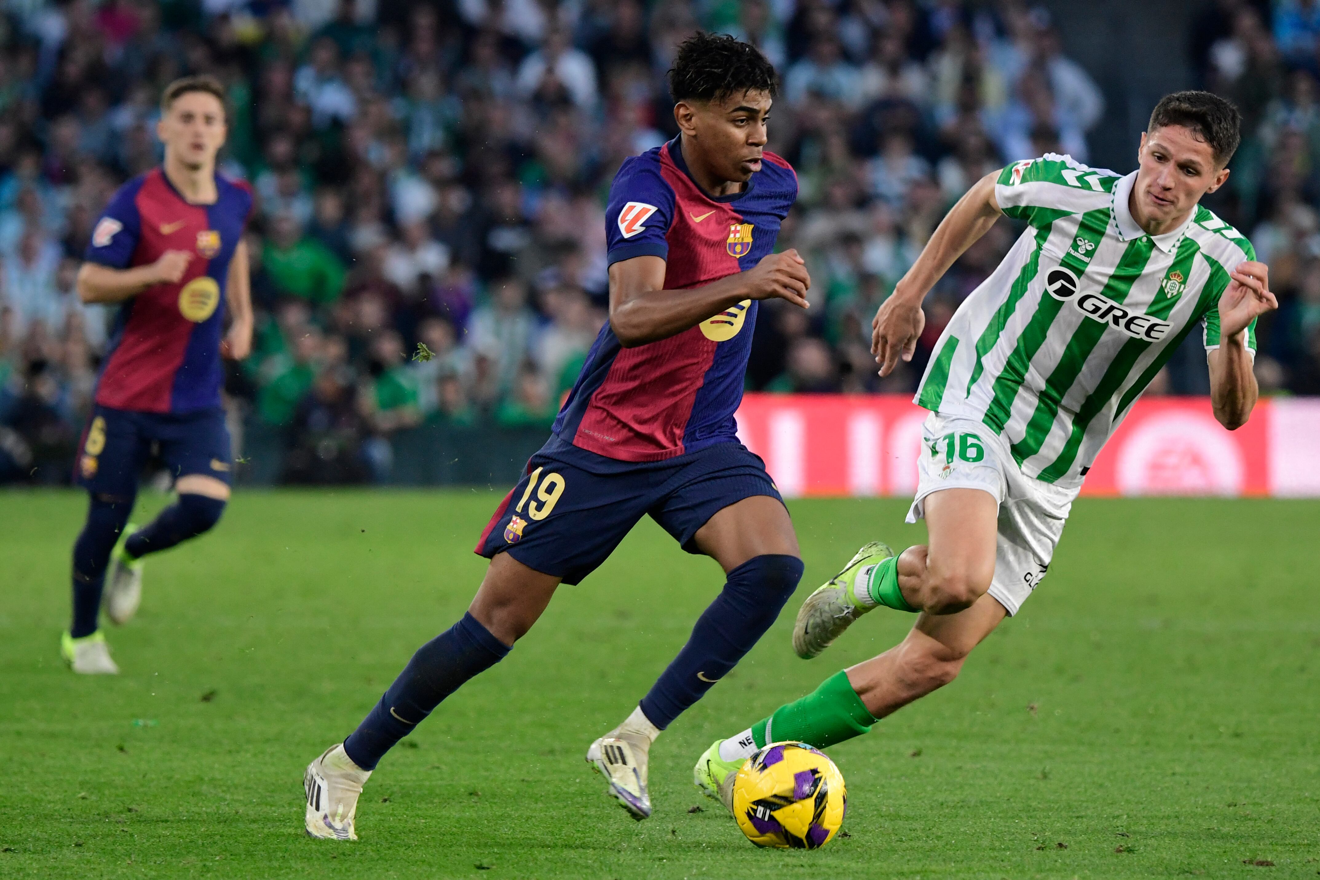 El delantero español del Barcelona #19 Lamine Yamal y el centrocampista español del Real Betis #16 Sergi Altimira compiten por el balón durante el partido de fútbol de la liga española.
