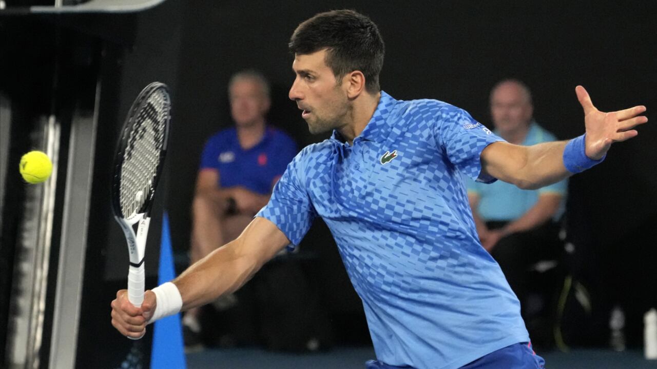 Novak Djokovic of Serbia plays a backhand return to Alex de Minaur of Australia during their fourth round match at the Australian Open tennis championship in Melbourne, Australia, Monday, Jan. 23, 2023. (AP/Aaron Favila)
