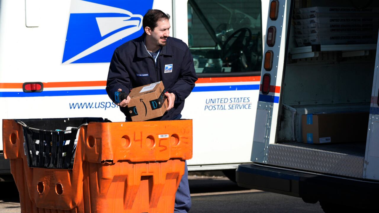 ARCHIVO - Un empleado del Servicio Postal de Estados Unidos carga paquetes ante una oficina de correos en Wheeling, Illinois, el 29 de enero de 2024. (AP Foto/Nam Y. Huh, Archivo)