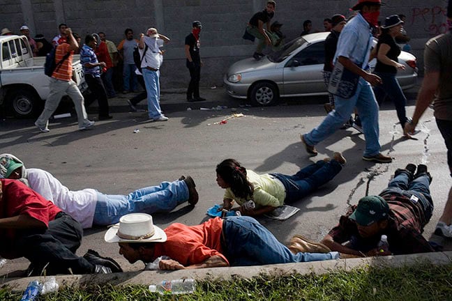 Manifestantes se esconden al escuchar los disparos