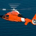 A rescue helicopter flying over water.