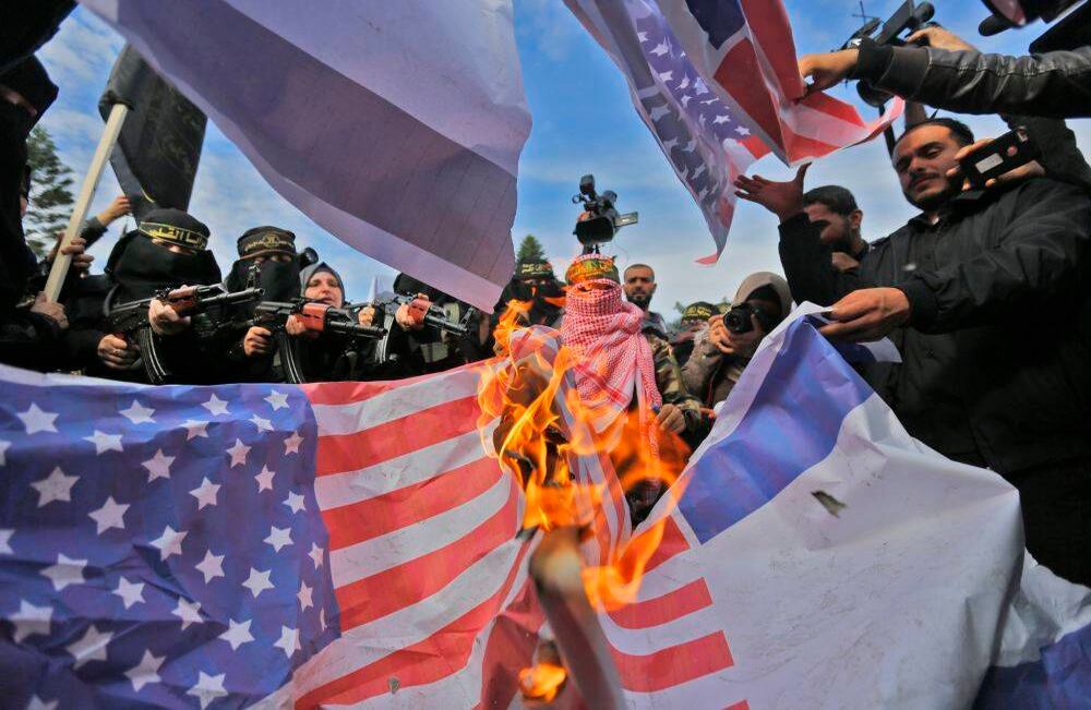 Los partidarios del militante grupo palestino Jihad Islámica queman banderas estadounidenses durante una protesta contra la decisión del presidente estadounidense Donald Trump de reconocer a Jerusalén como la capital de Israel, en la ciudad de Gaza el 11 de diciembre de 2017. MOHAMMED ABED / AFP