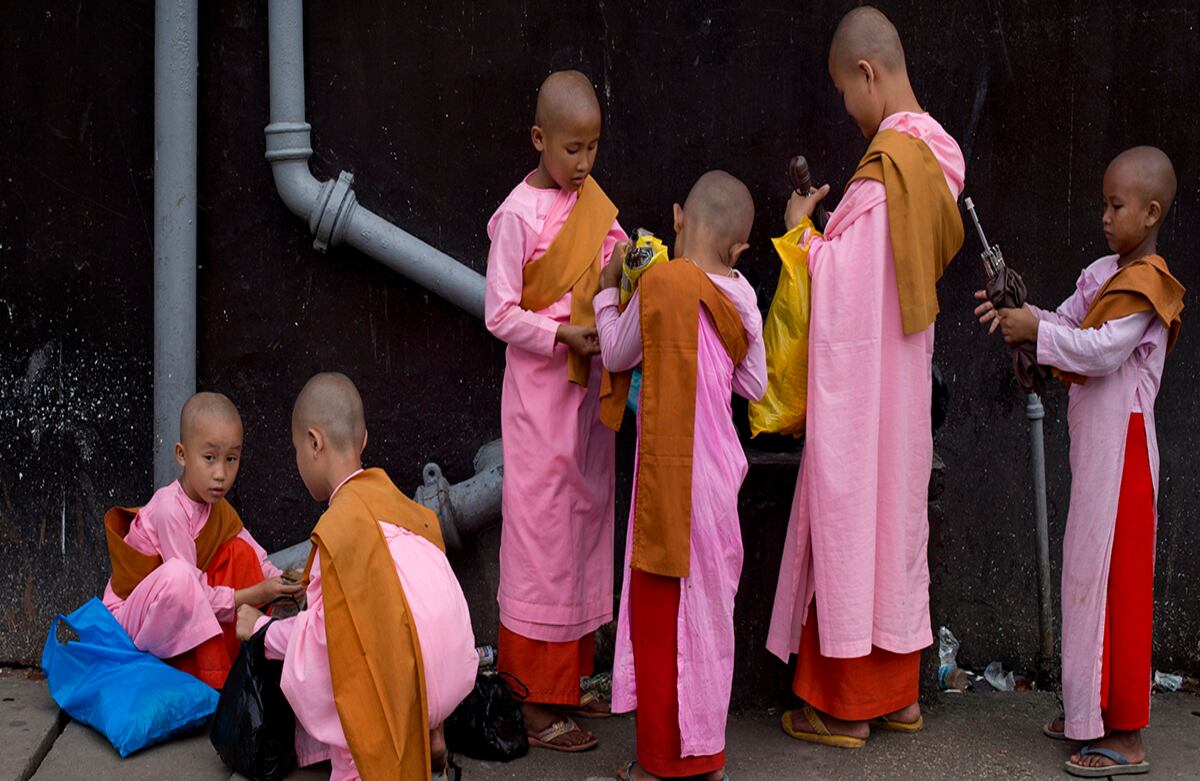 Aprendices de monje budista empacan sus cosas luego de haber pasado un día pidiendo limosna en las calles de Yangon, Myanmar. (AP)