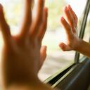 Child's hands touching car window