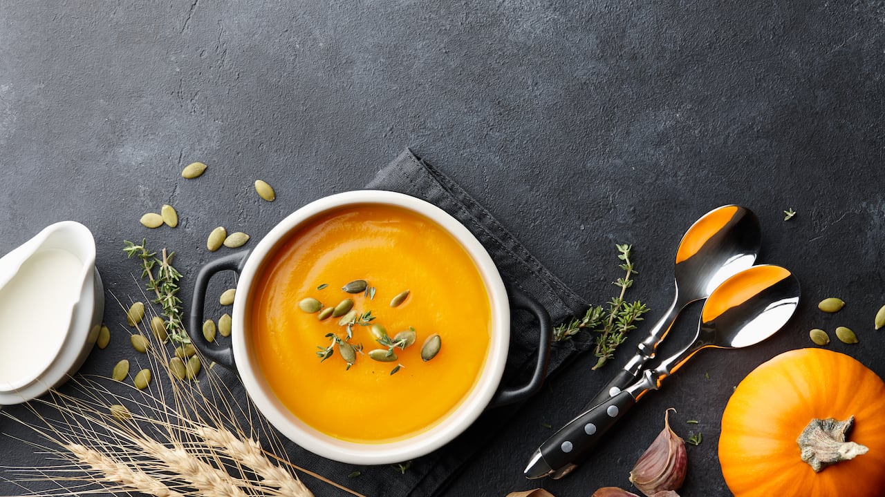 Sopa de calabaza con semillas de tomillo y calabaza sobre fondo negro. Auyama, ahuyama, alimentos, crema