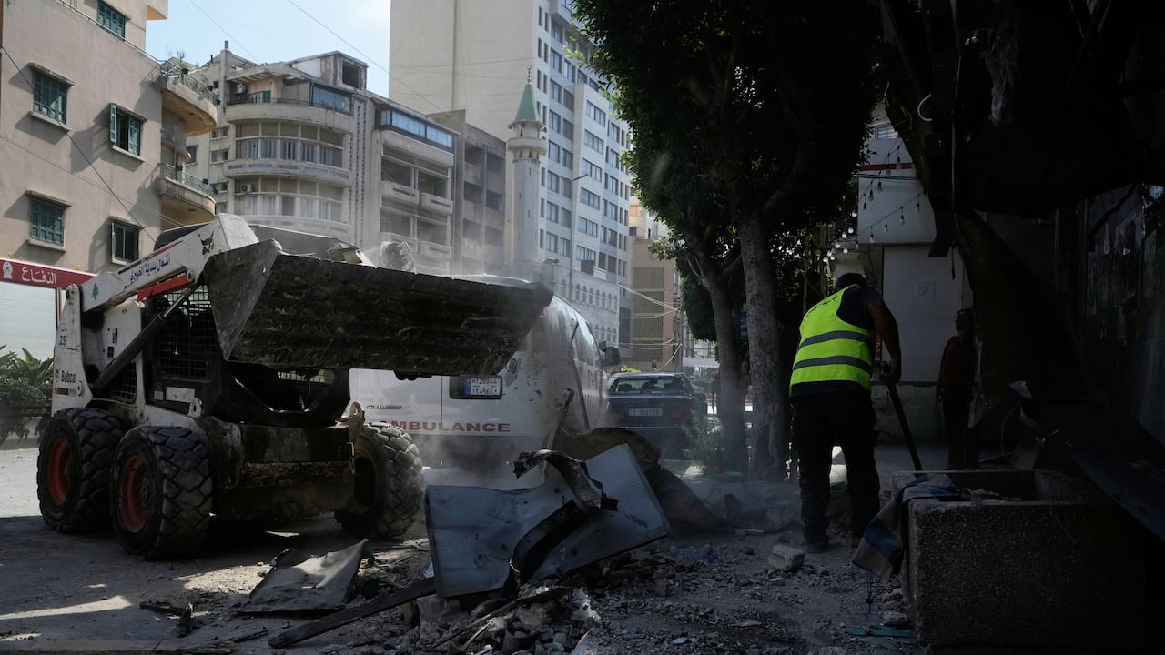 Trabajadores retiran escombros cerca de un edificio de apartamentos dañado por un ataque aéreo israelí en Dahiyeh, en los suburbios del sur de Beirut, Líbano.