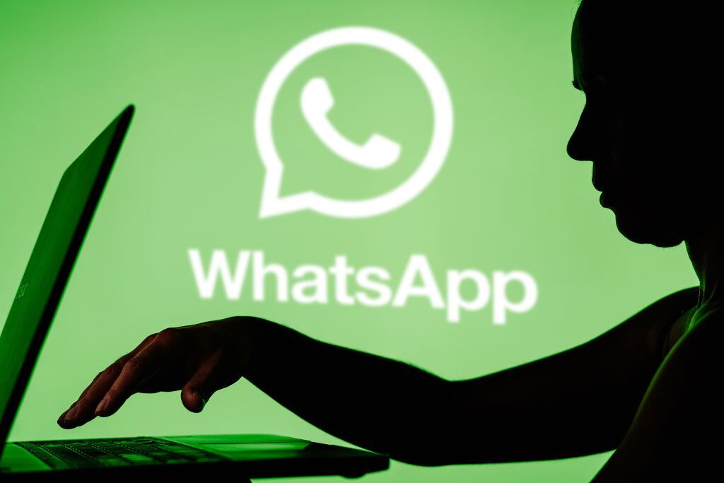 BRAZIL - 2024/03/27: In this photo illustration, the WhatsApp logo is seen in the background and a silhouette of a person using a notebook. (Photo Illustration by Rafael Henrique/SOPA Images/LightRocket via Getty Images)