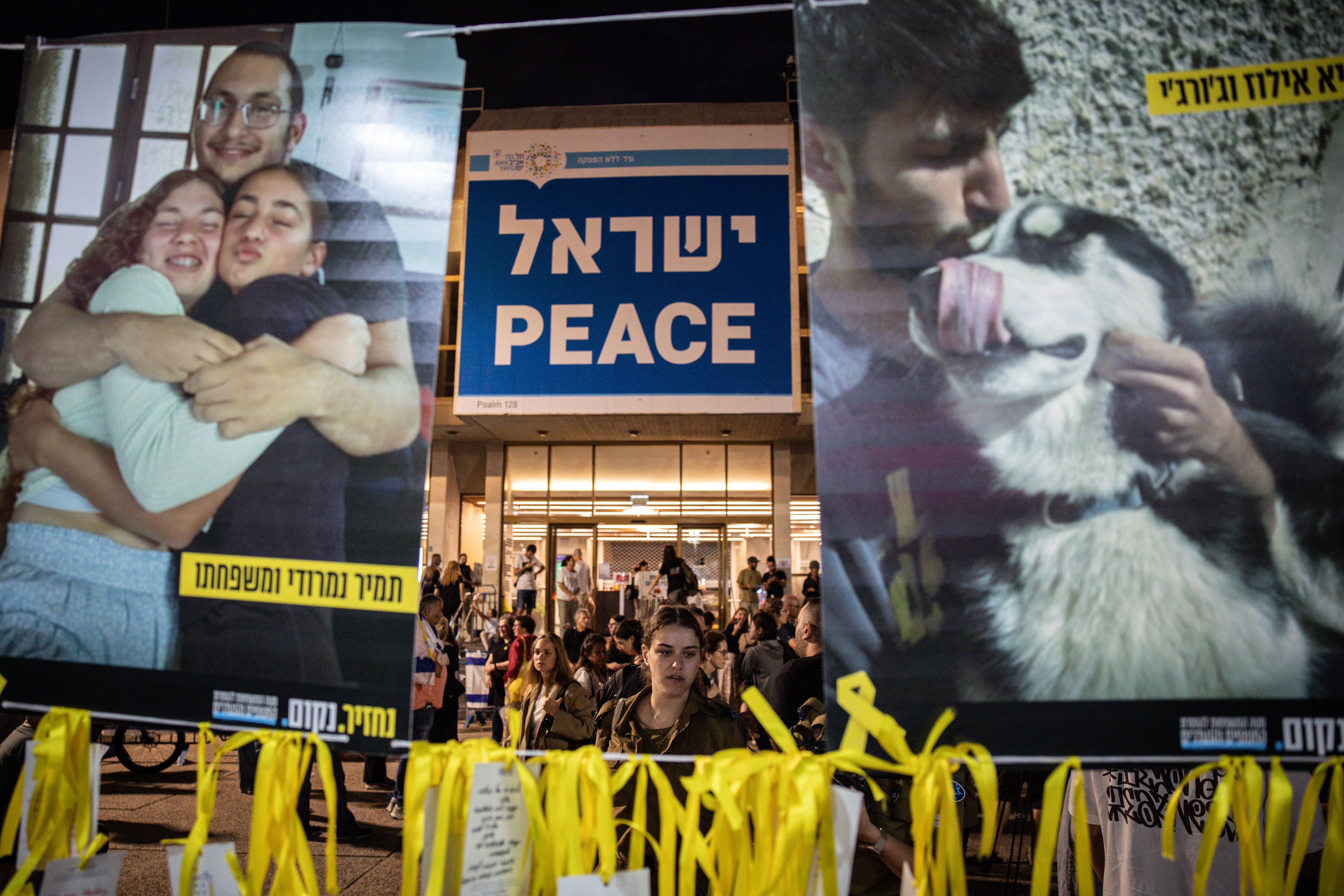 TEL AVIV - OCTOBER 12: A woman looks at photographs of hostages hanging at Hostages Square on October 12, 2025 in Tel Aviv, Israel This week's ceasefire deal between Israel and Hamas has brought an end to the two years of war that followed the attacks of Oct. 7, 2023. A condition of the deal is the return of 48 hostages held in Gaza, 20 of whom are believed to be alive. (Photo by Chris McGrath/Getty Images)