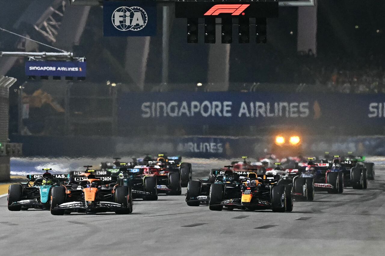 McLaren's British driver Lando Norris (2nd L) leads the pack as he drives at the start of the Formula One Singapore Grand Prix night race at the Marina Bay Street Circuit in Singapore on September 22, 2024. (Photo by Lillian SUWANRUMPHA / AFP)