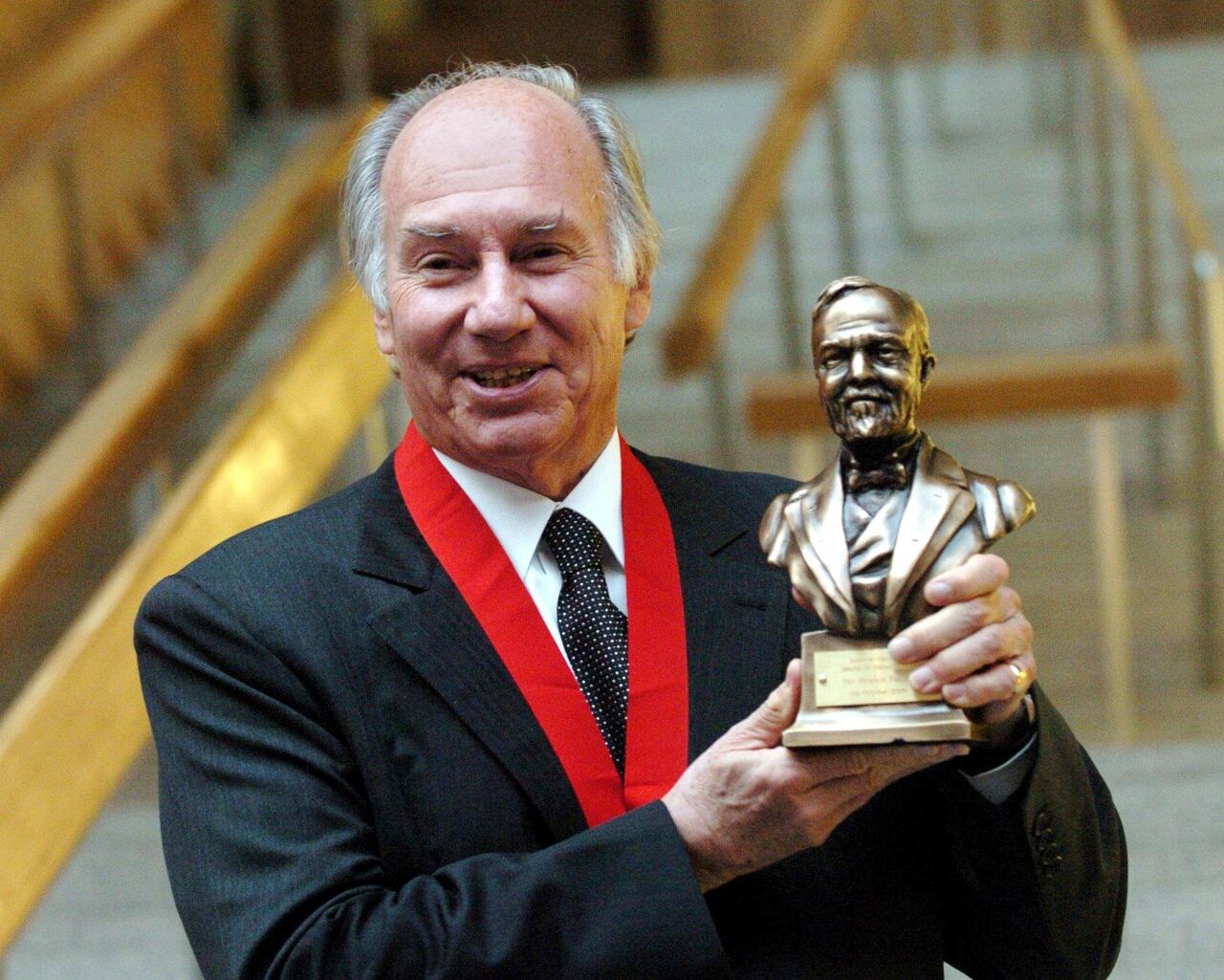 FILE - The Aga Khan holds the Andrew Carnegie Medal of Philanthropy after being presented with the prestigious award for philanthropy during a ceremony at the Scottish Parliament in Edinburgh, Scotland, Oct. 4, 2005. (Danny Lawson/PA via AP, File)