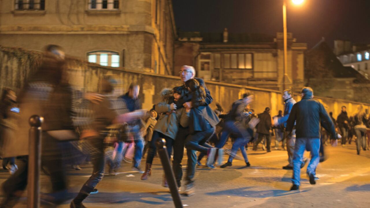 Un hombre protege a sus dos hijos de una estampida que se produjo cerca del Petit Cambodge, uno de los sitios atacados el 13 de noviembre.