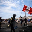 Simpatizantes del destituido presidente peruano Pedro Castillo protestan en la autopista Panamericana Norte mientras agentes de policía llegan para despejar la vía de escombros, en Chao, Perú, el jueves 15 de diciembre de 2022.