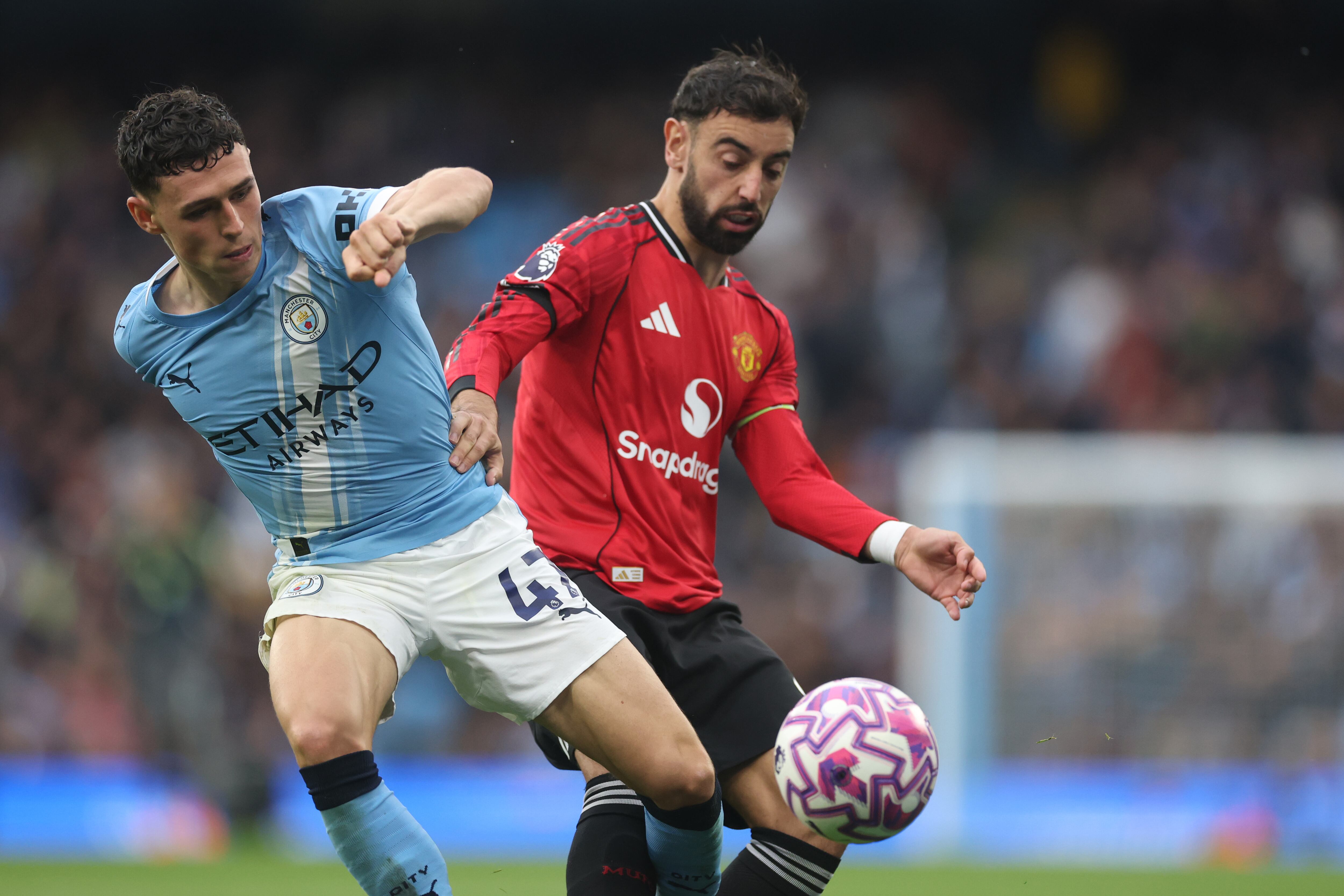 MANCHESTER, ENGLAND - SEPTEMBER 14: Phil Foden of Manchester City battles for possession with Bruno Fernandes of Manchester United during the Premier League match between Manchester City and Manchester United at Etihad Stadium on September 14, 2025 in Manchester, England. (Photo by Carl Recine/Getty Images)