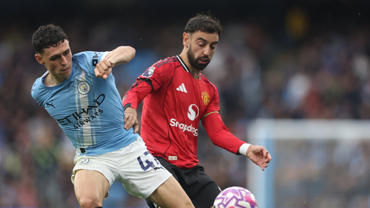 Phil Foden pelea una pelota contra Bruno Fernandes en el derbi de Manchester.