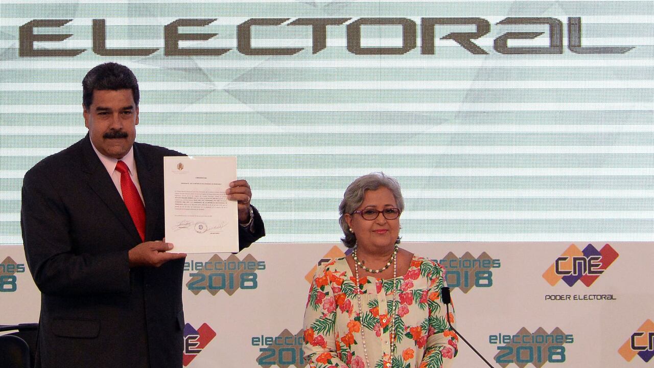 El presidente venezolano, Nicolás Maduro (izq.), muestra el documento emitido por el Consejo Nacional Electoral que lo proclama reelegido para el período 2019-2025, junto a la presidenta del CNE, Tibisay Lucena, en la sede del CNE en Caracas el 22 de mayo de 2018.