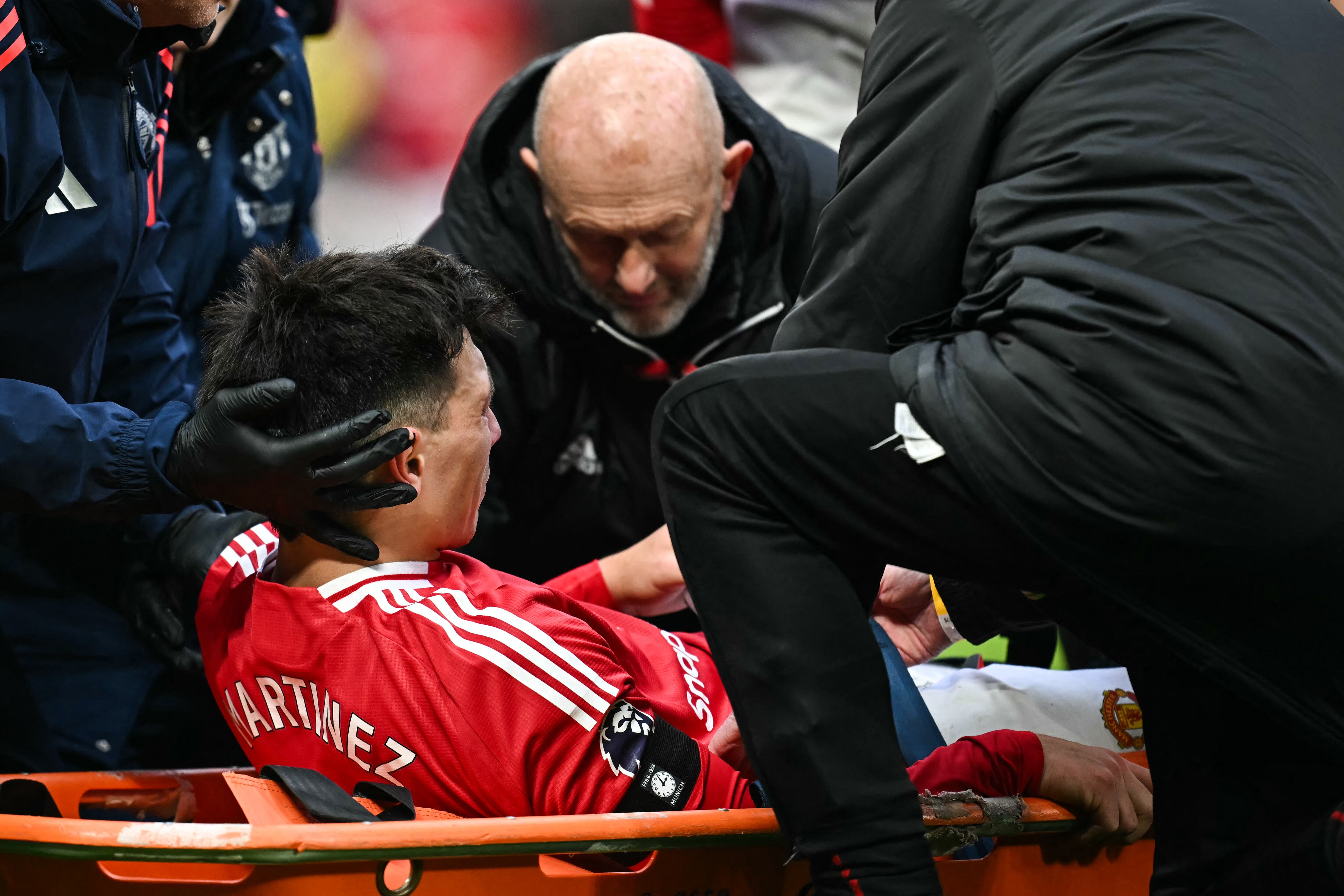 Manchester United's Argentinian defender #06 Lisandro Martinez reacts as he is evacuated on a stretcher following an injury during the English Premier League football match between Manchester United and Crystal Palace at Old Trafford in Manchester, north west England, on February 2, 2025. (Photo by Paul ELLIS / AFP) / RESTRICTED TO EDITORIAL USE. No use with unauthorized audio, video, data, fixture lists, club/league logos or 'live' services. Online in-match use limited to 120 images. An additional 40 images may be used in extra time. No video emulation. Social media in-match use limited to 120 images. An additional 40 images may be used in extra time. No use in betting publications, games or single club/league/player publications. /