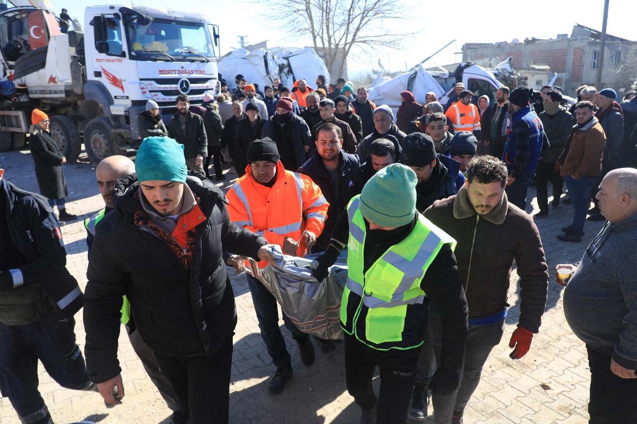 Los rescatistas llevan a una persona recuperada de los escombros de un edificio derrumbado, en Nurdagi, en el campo de Gaziantep, el 9 de febrero de 2023, tres días después de un terremoto mortal que azotó Turquía y Siria. (Photo by Zein Al RIFAI / AFP)