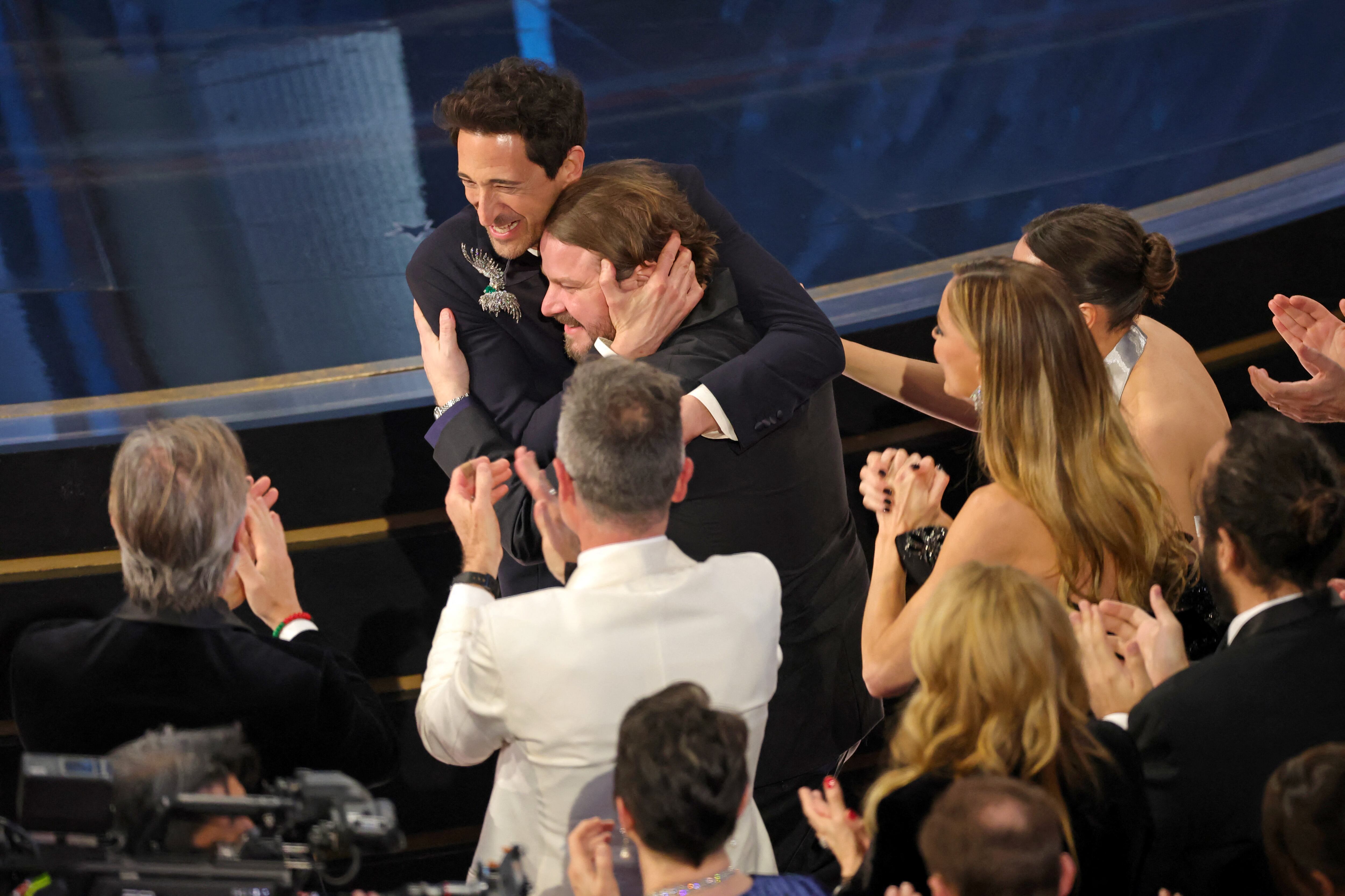 HOLLYWOOD, CALIFORNIA - MARCH 02: Adrien Brody with Brady Corbet as he accepts the Best Actor In A Leading Role award for "The Brutalist" during the 97th Annual Oscars at Dolby Theatre on March 02, 2025 in Hollywood, California.   Kevin Winter/Getty Images/AFP (Photo by KEVIN WINTER / GETTY IMAGES NORTH AMERICA / Getty Images via AFP)