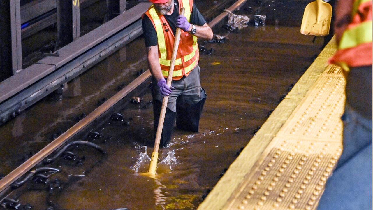 Esta fotografía proporcionada por el servicio MTA New York City Transit, muestra a un trabajador metido en las vías inundadas de la estación de metro de Times Square, en Nueva York, el martes 29 de agosto de 2023. (Marc A. Hermann / MTA, via AP).