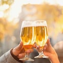 Pareja brindando con vasos de cerveza