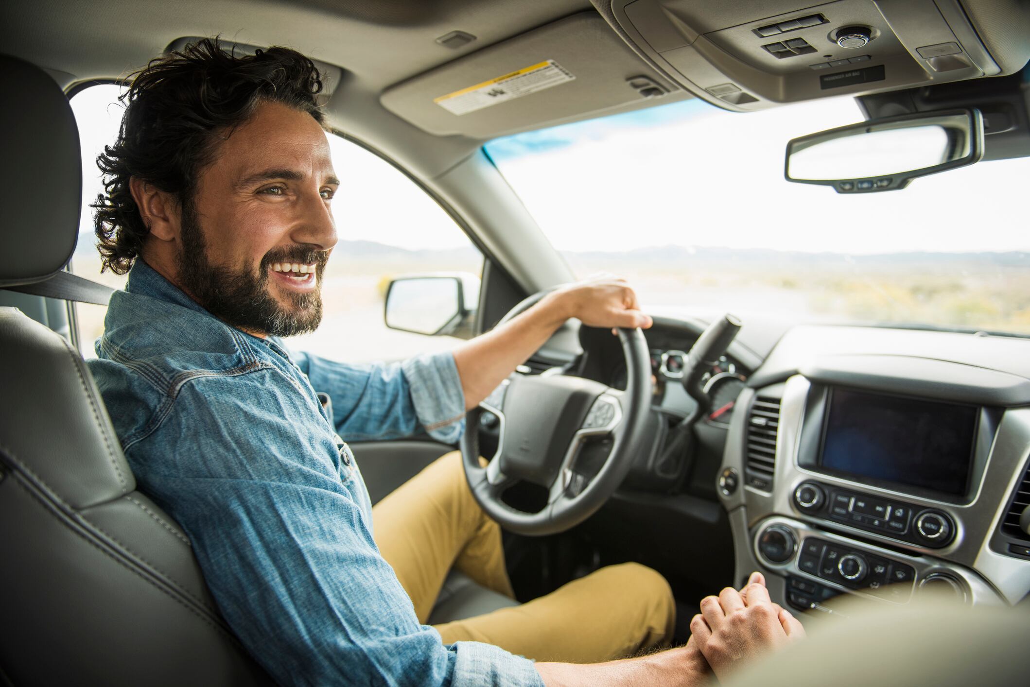 Hispanic couple holding hands in car