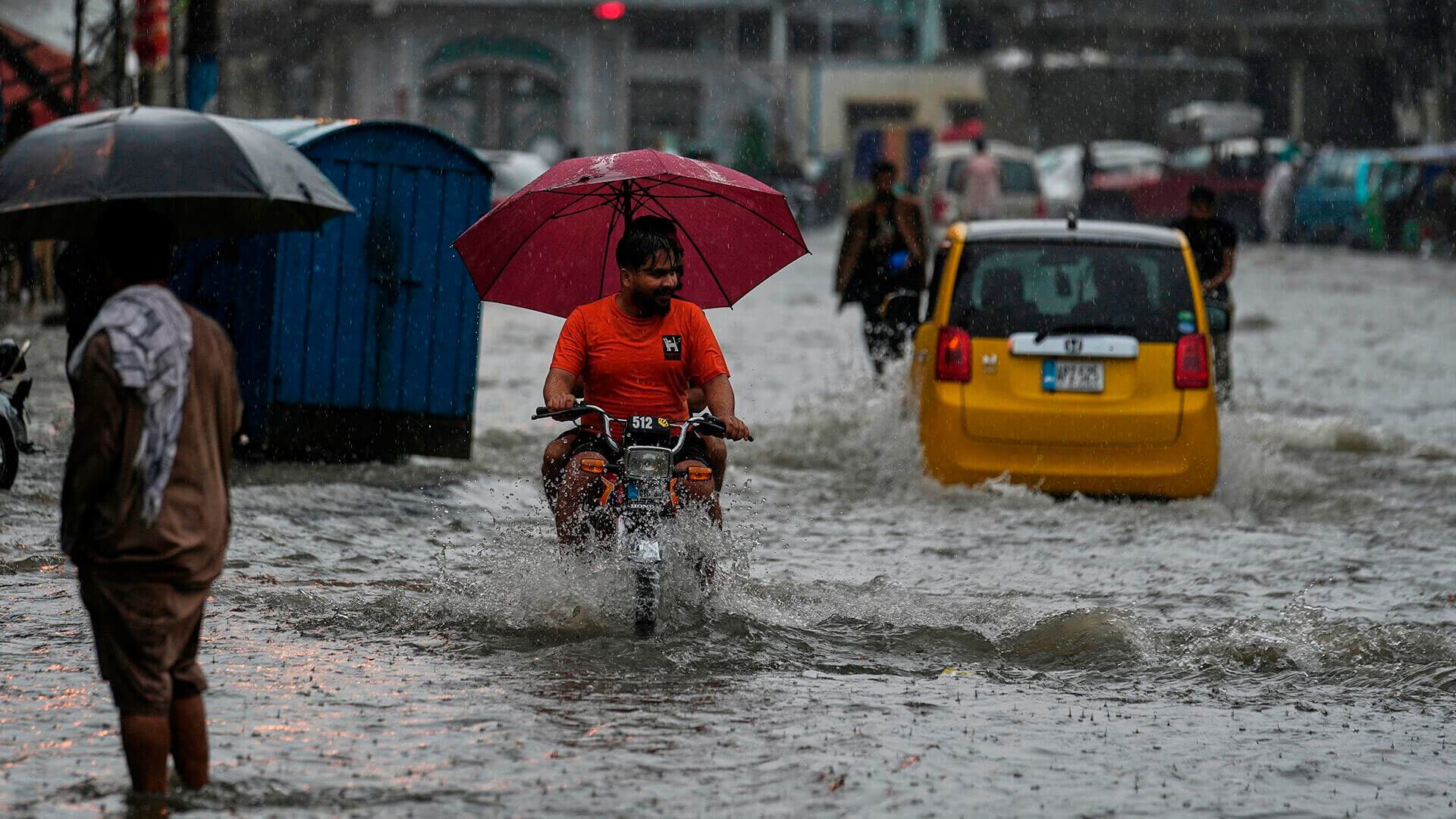 Los automovilistas conducen por una carretera inundada durante las lluvias monzónicas, en Rawalpindi, Pakistán. Jueves 17 de julio de 2025.
