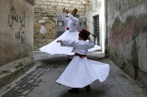 El bailarín derviche sufí Muayad al-Kharrat (detrás), de 28 años, baila con su hijo de tres años, Anas (delante), junto a su casa en el distrito de Shahgur de la ciudad vieja de Damasco, capital de Siria, el 6 de mayo de 2021. Foto de LOUAI BESHARA / AFP
