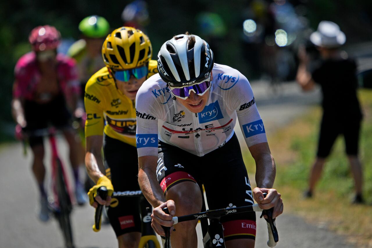 ARCHIVO - Tadej Pogacar (camiseta blanca) trata de desprenderse de Jonas Vingegaard (casaca amarilla de líder general) durante la 18va etapa del Tour de Francia, el jueves 21 de julio de 2022. (AP Foto/Daniel Cole)