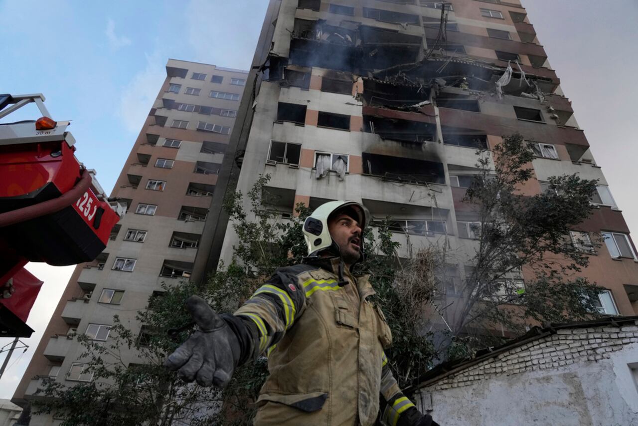 Un bombero frente a un edificio residencial de Teherán, Irán, el viernes 13 de junio de 2025 donde se registró una explosión. Israel atacó diversos puntos de la capital iraní la madrugada del viernes. (AP Foto/Vahid Salemi)