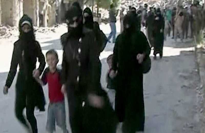 Mujeres y niños que llegan en una calle bordeada de edificios han sufrido grandes daños en la parte controlada por el Gobierno de Salaheddine de Alepo, Siria . 30 de julio del 2016. Foto: AP