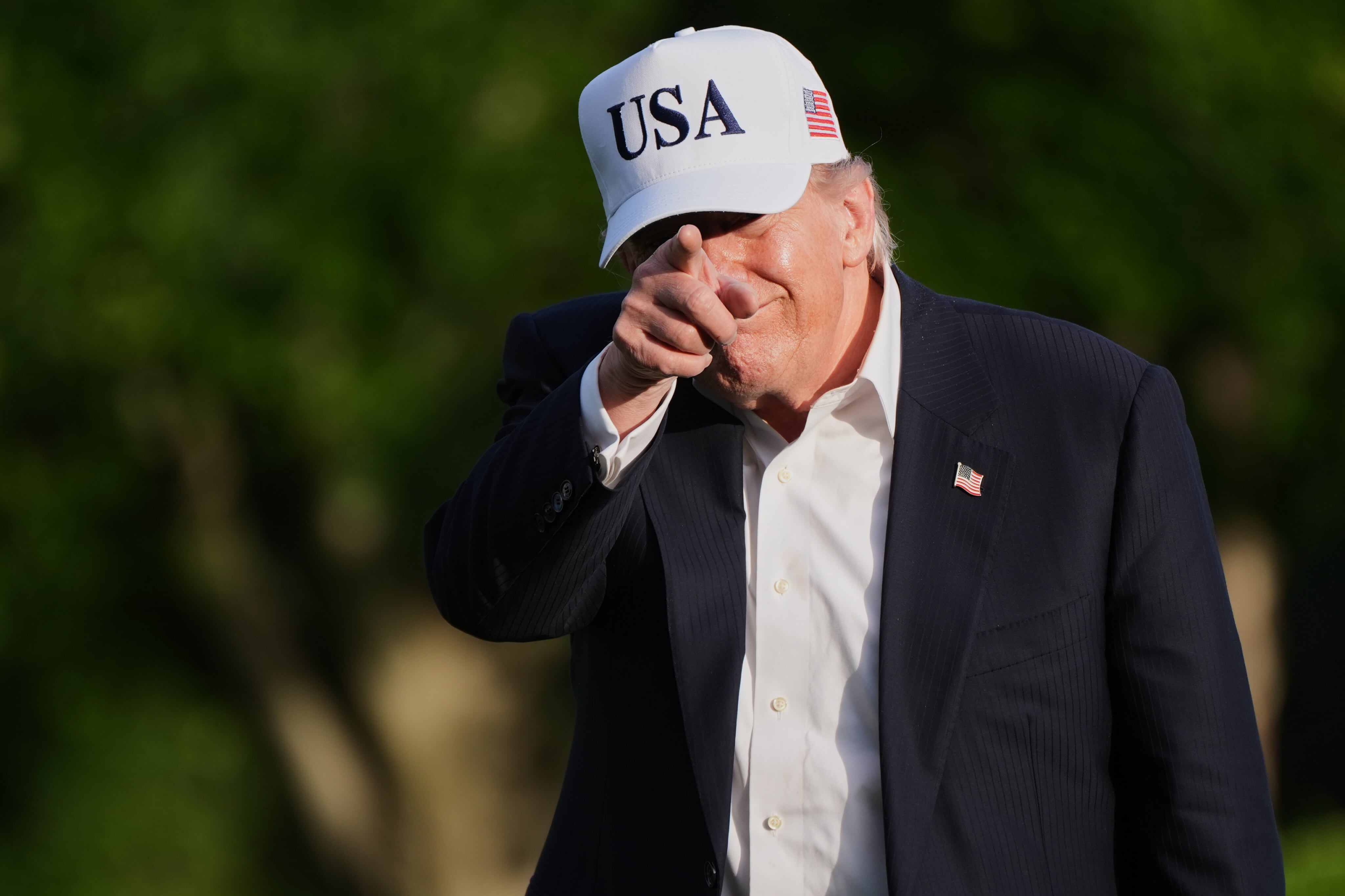 El presidente Donald Trump saluda a los periodistas mientras camina por el jardín sur de la Casa Blanca a su regreso de Pekín.