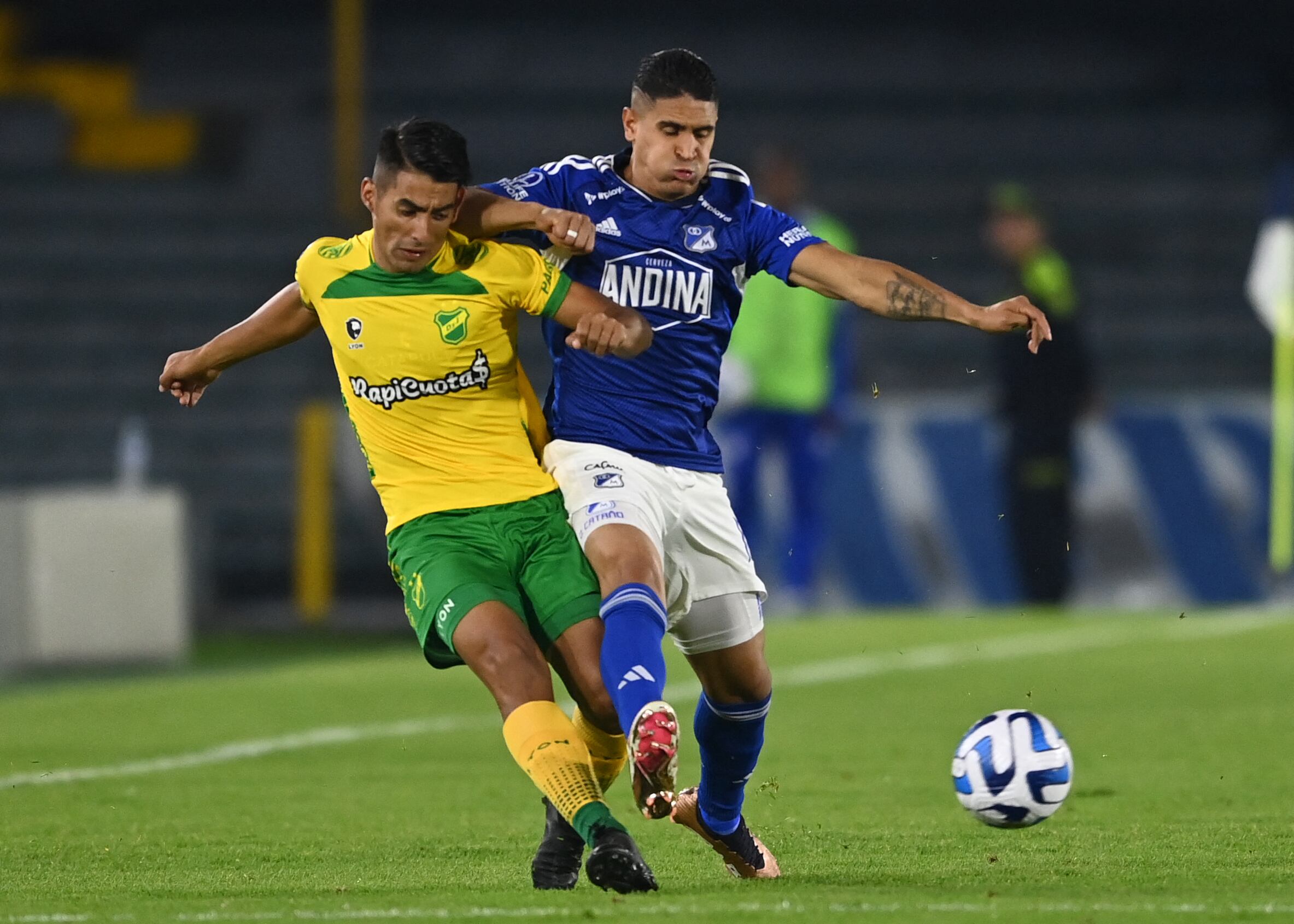 Daniel Cataño peleando un balón con rival de Defensa y Justicia.