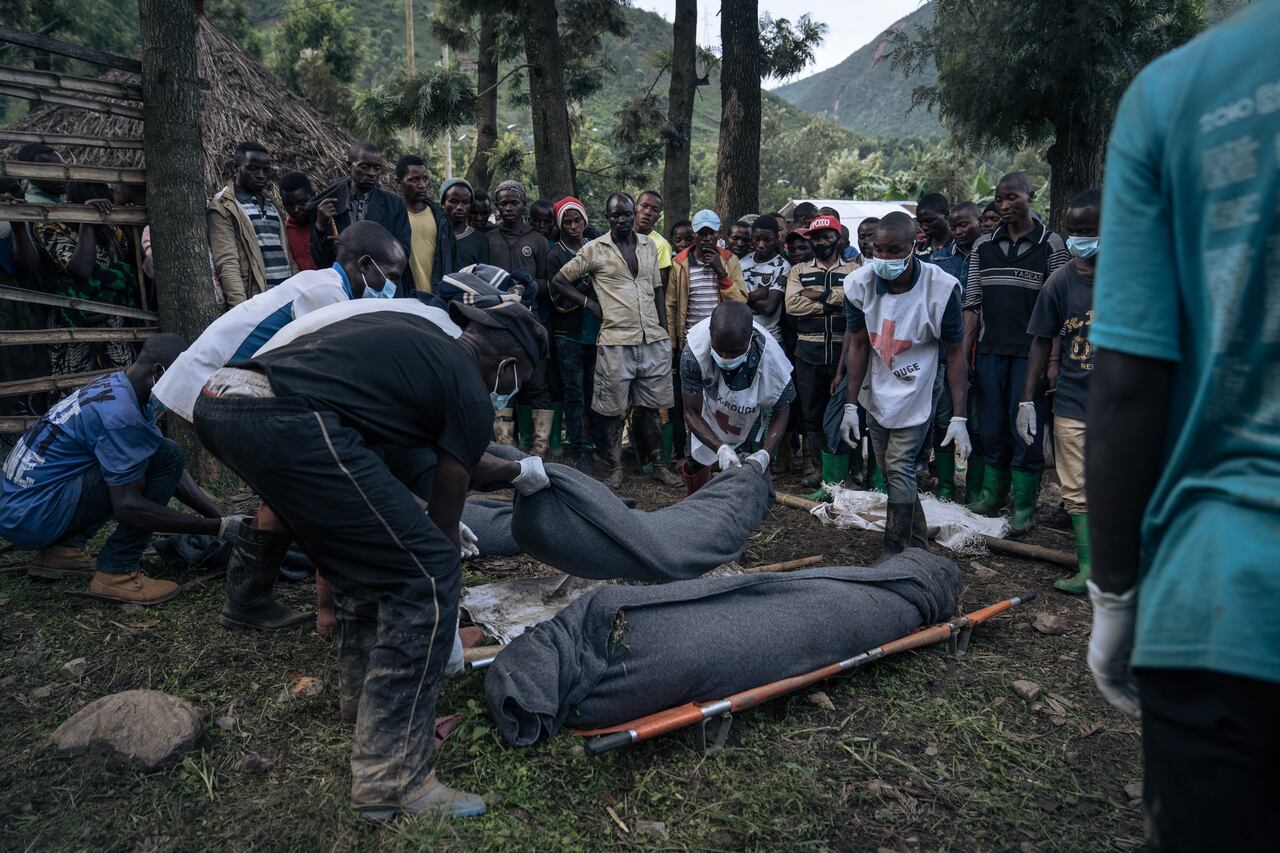 Voluntarios de la Cruz Roja Congoleña y residentes de Nyamukubi envuelven en mantas los cuerpos de las personas que murieron en las fuertes inundaciones en el este de la República Democrática del Congo