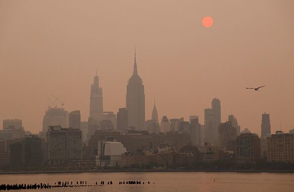 El sol está envuelto a medida que se eleva en un cielo brumoso y humeante detrás del Empire State Building, One Vanderbilt y el Chrysler Building en la ciudad de Nueva York el 6 de junio de 2023, visto desde Jersey City, Nueva Jersey. (Foto de Gary Hershorn/Getty Images)