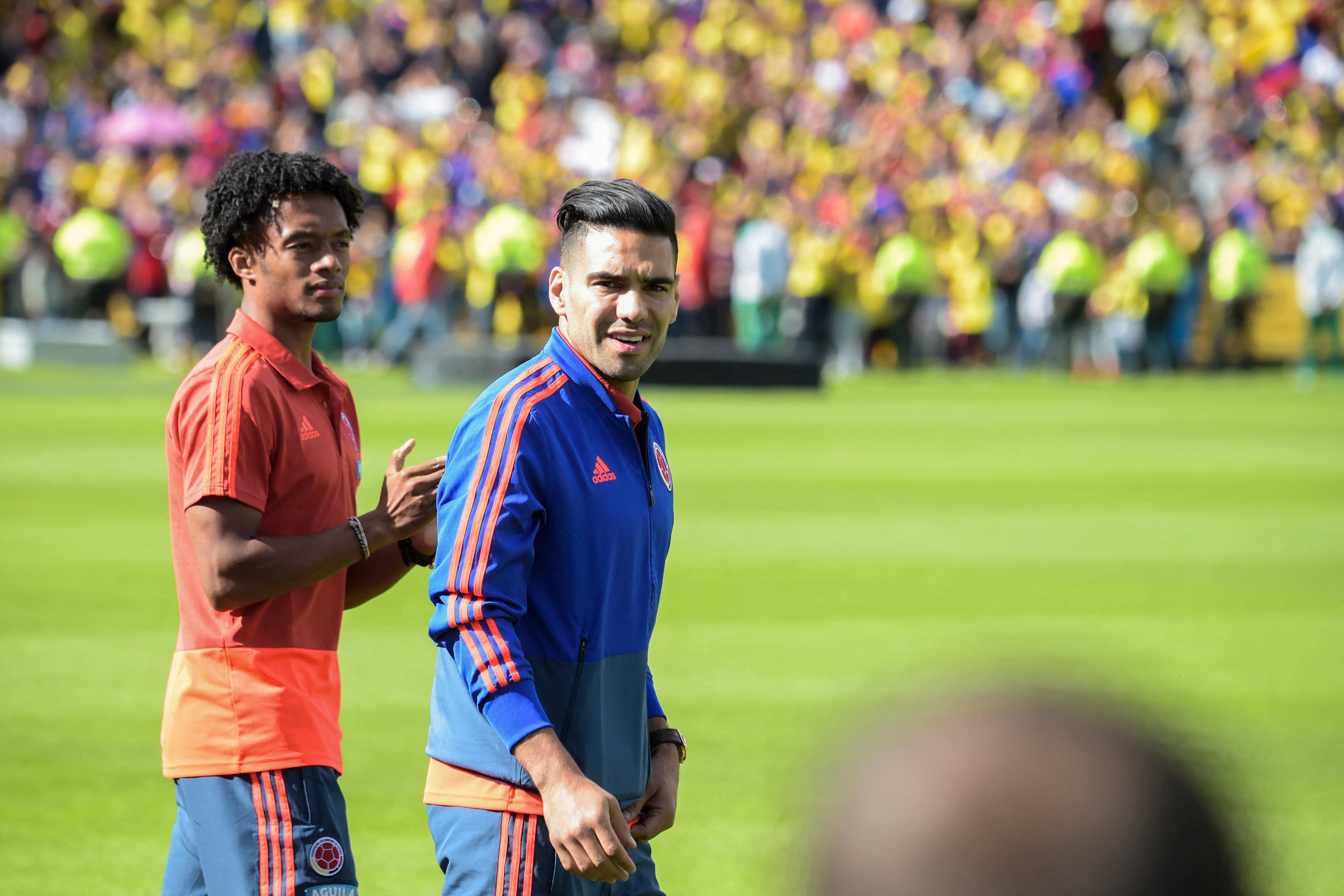 Colombian national team players Radamel Falcao (R) and Juan Cuadrado enter the field during their welcoming ceremony at El Campin stadium in Bogota on July 5, 2018, after their participation in the FIFA World Cup. England beat Colombia in a dramatic penalty shootout in Moscow on July 3 to reach the World Cup quarter-finals. (Photo by Raul ARBOLEDA / AFP)
