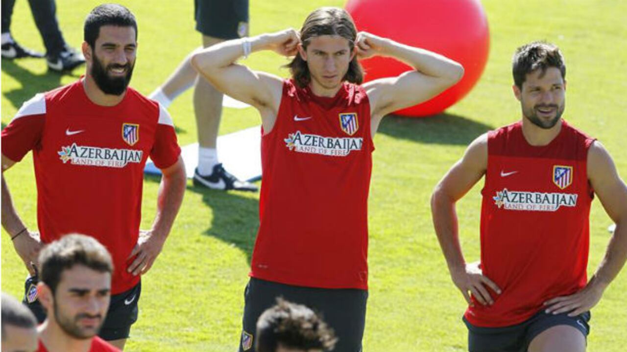 Los jugadores del Atlético de Madrid, Arda Turan, Filipe Luis y Diego Ribas, durante el entrenamiento realizado en la Ciudad Deportiva Rojiblanca para preparar el partido de liga contra el Málaga el próximo domingo.