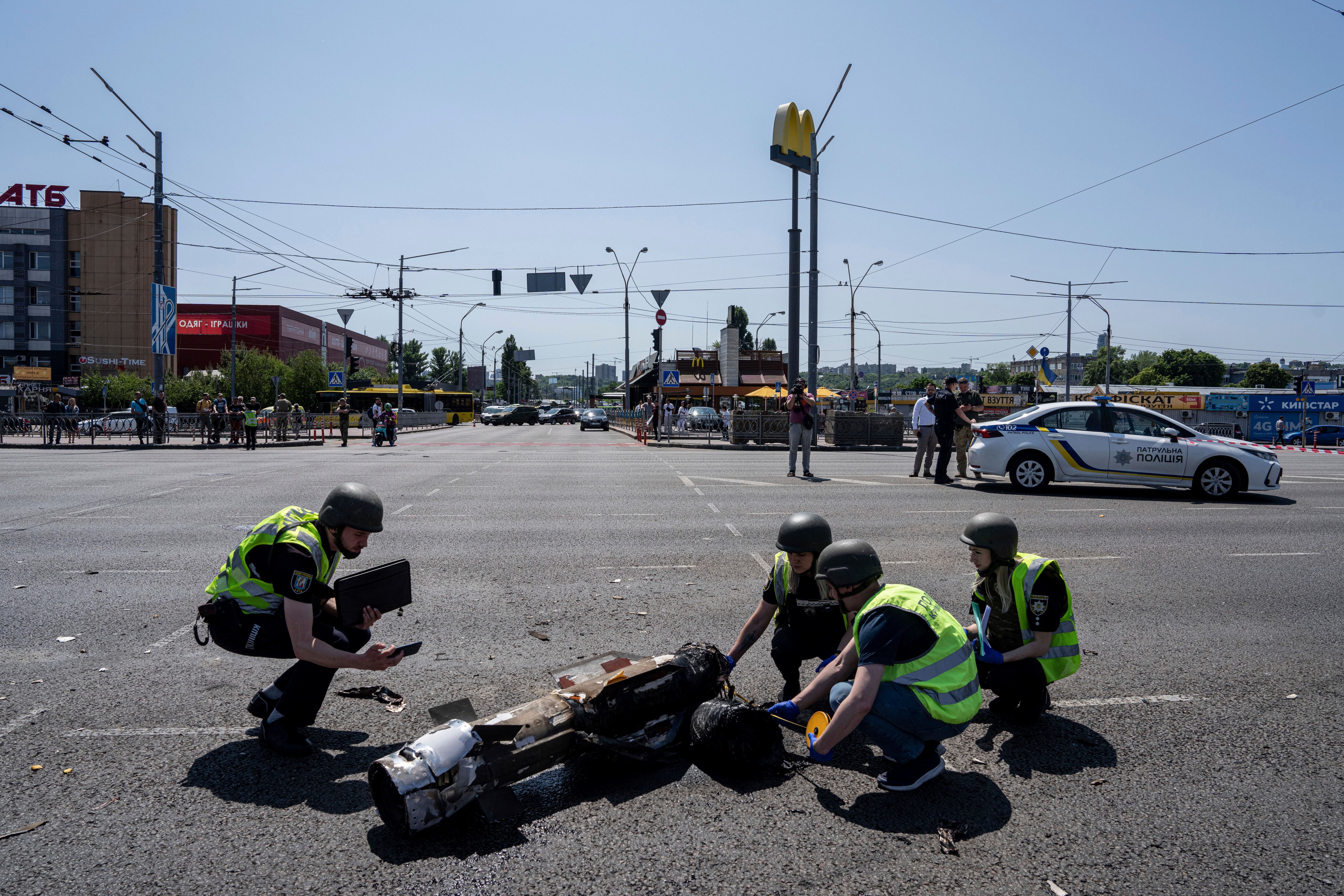 Agentes de la policía ucraniana inspeccionan un fragmento del cohete después de un ataque con cohetes rusos en Kiev, Ucrania, el lunes 29 de mayo de 2023.