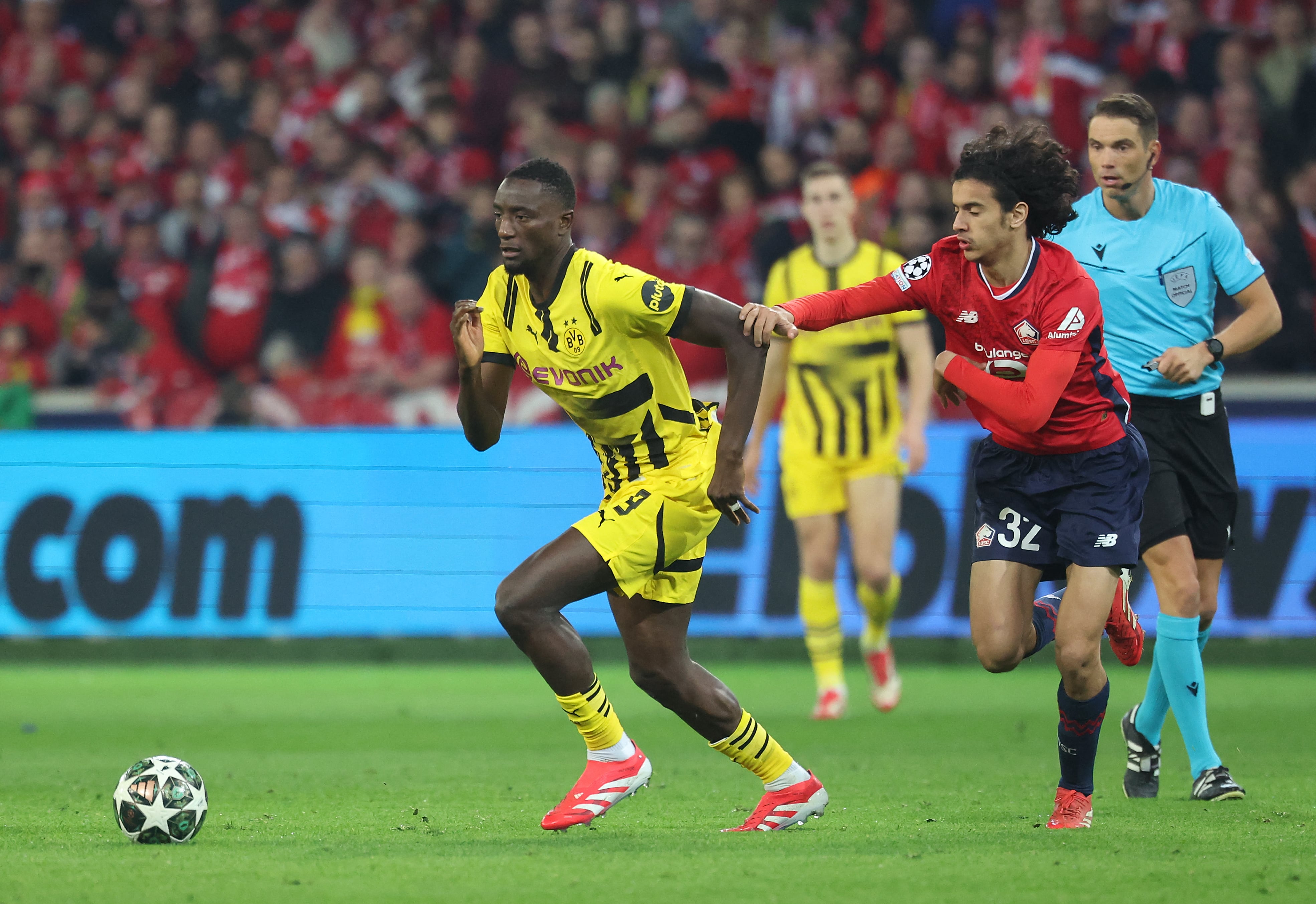 Borussia Dortmund's Guinean forward #09 Sehrou Guirassy (L) fights for the ball with Lille's French midfielder #32 Ayyoub Bouaddi during the UEFA Champions League last 16, second leg football match between OSC Lille and Borussia Dortmund at the Pierre Mauroy stadium in Lille, northern France, on March 12, 2025. (Photo by Francois LO PRESTI / AFP)